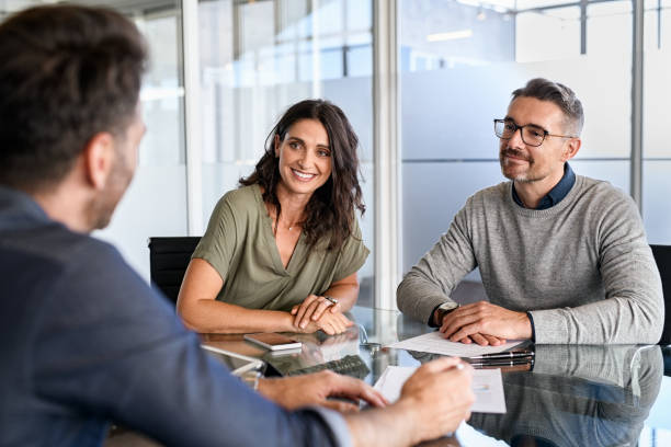 Claims Processing and Automation 2 Insurance clients discussing automated claims processing with an advisor in a professional office setting.