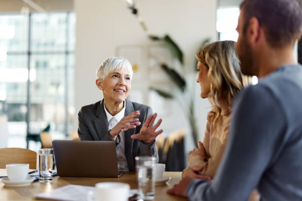 Claims Processing and Automation 1 Smiling insurance advisor discussing AI-powered claims automation with clients in a modern office setting.
