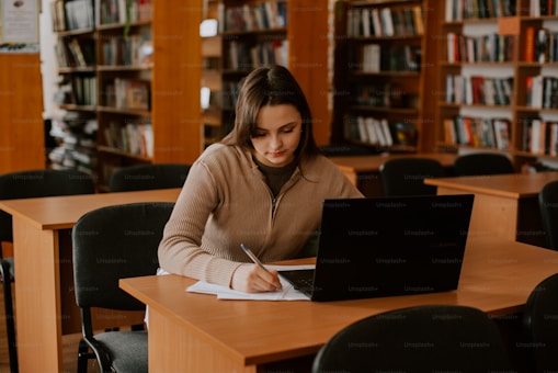 Careers 3 Focused professional upskilling through online learning at a library workspace.