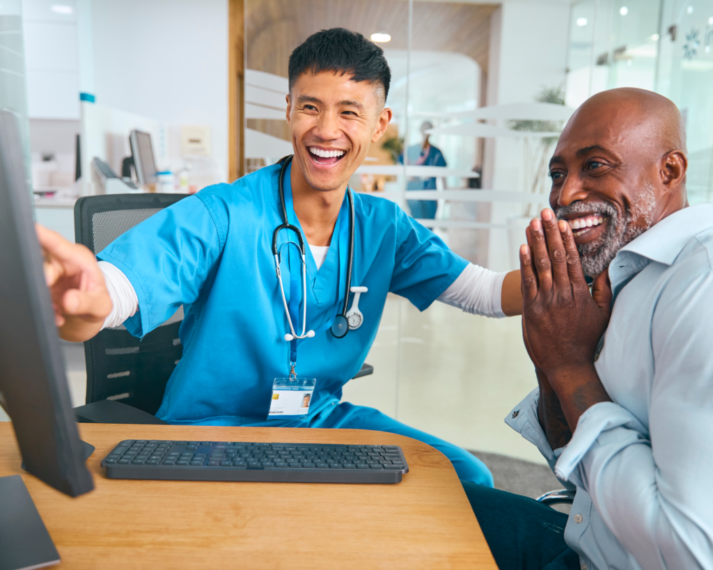 Customer Engagement & Experience for Payers 1 Smiling healthcare provider showing a positive insurance claim outcome to a happy patient at a modern medical facility.
