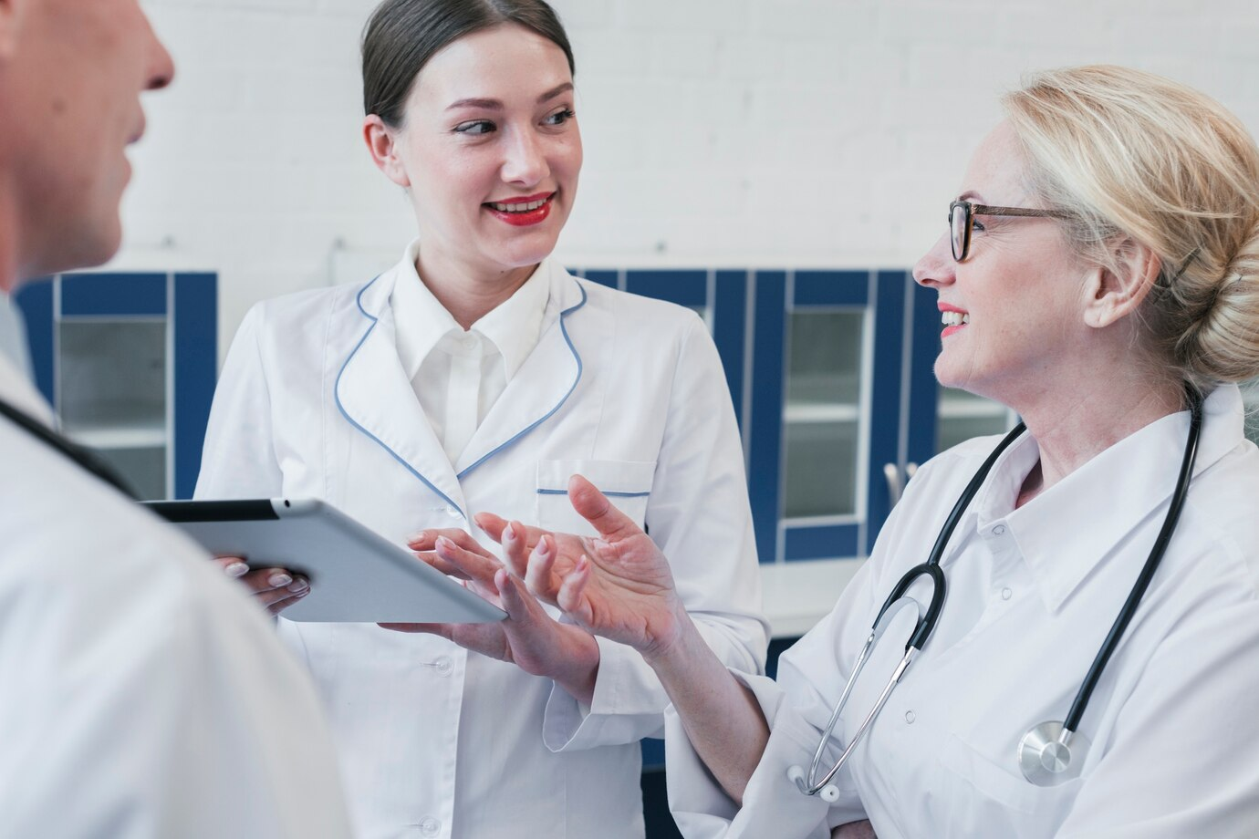 Pharmacovigilance & Safety Monitoring 15 Pharma team discussing AI-powered literature search transformation in a clinical setting with a digital tablet.