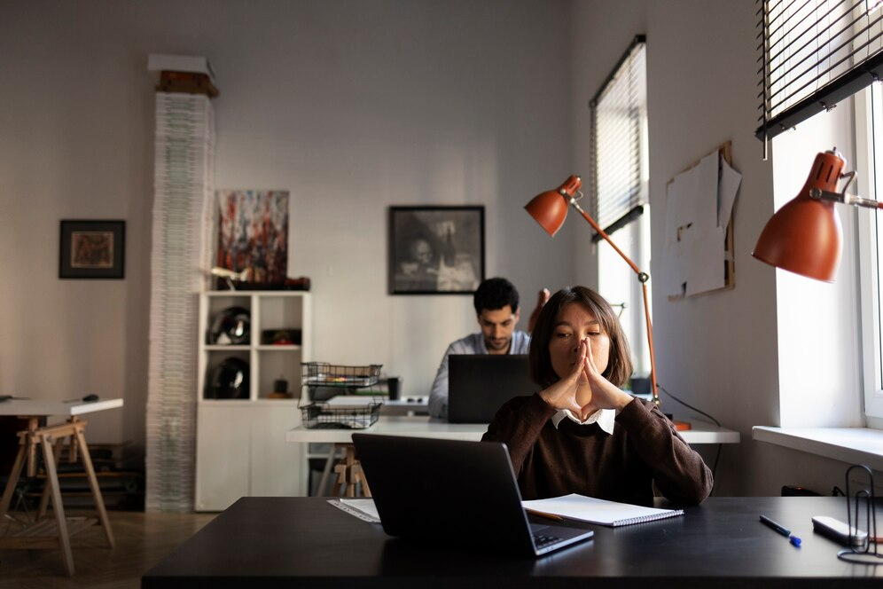 Careers 12 Focused employee reflecting during a quiet moment at a modern office workstation.