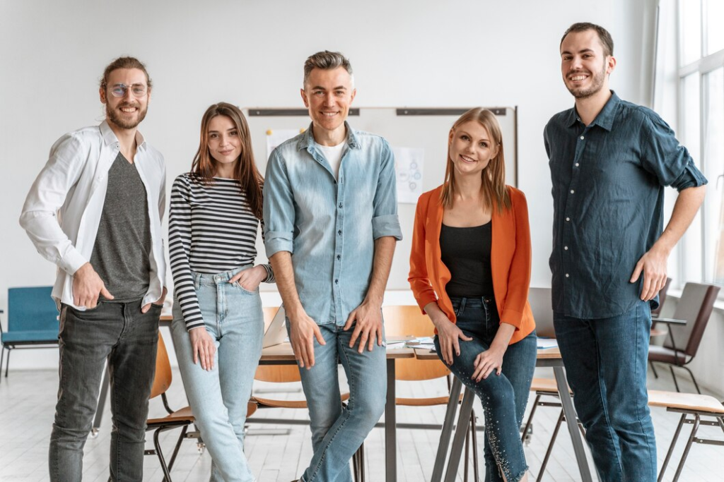 About Us 13 Confident and diverse team posing together in a bright, modern office setting.